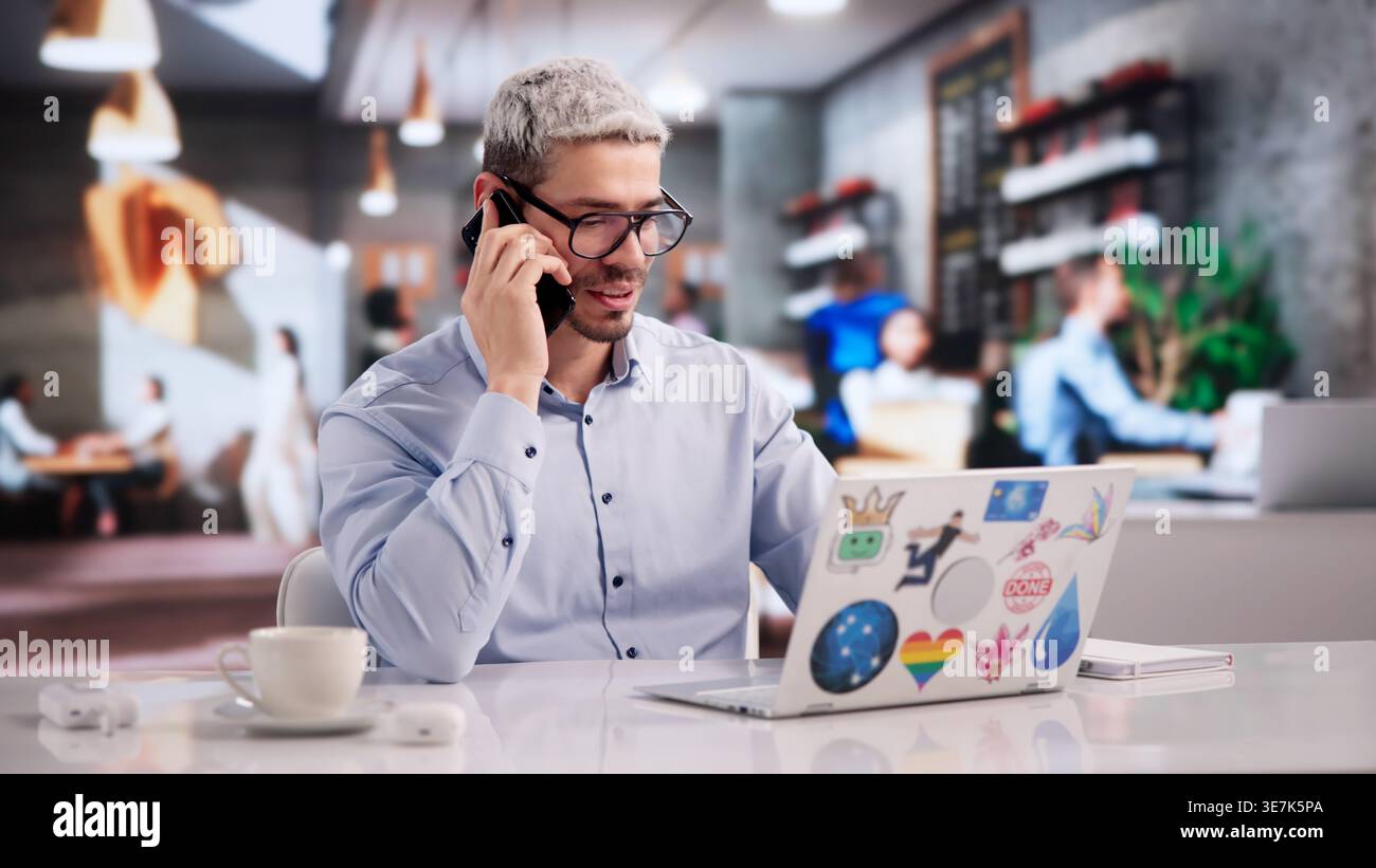 Creative Graphic Designer Collaborating With Client Over Phone While Crafting Web Art On Laptop Stock Photo