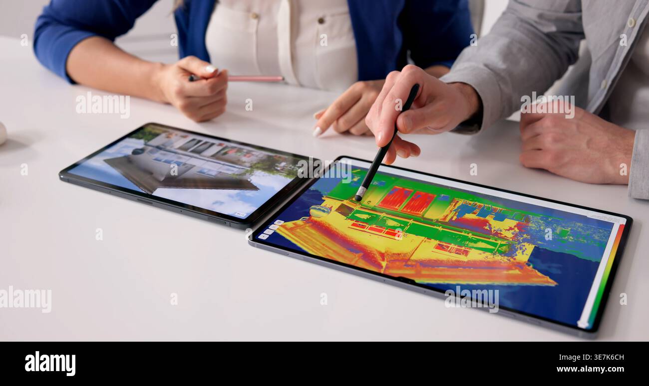 Thermal Imaging Specialist Examines Home Insulation For Heat Loss Detection Stock Photo