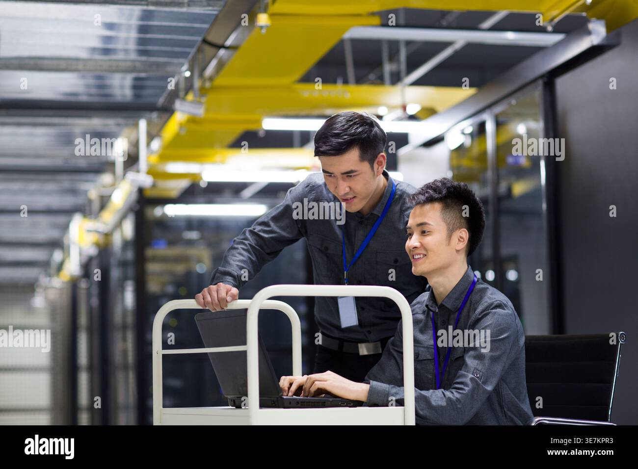 Chinese male technicians doing maintenance using laptop in computer room Stock Photo