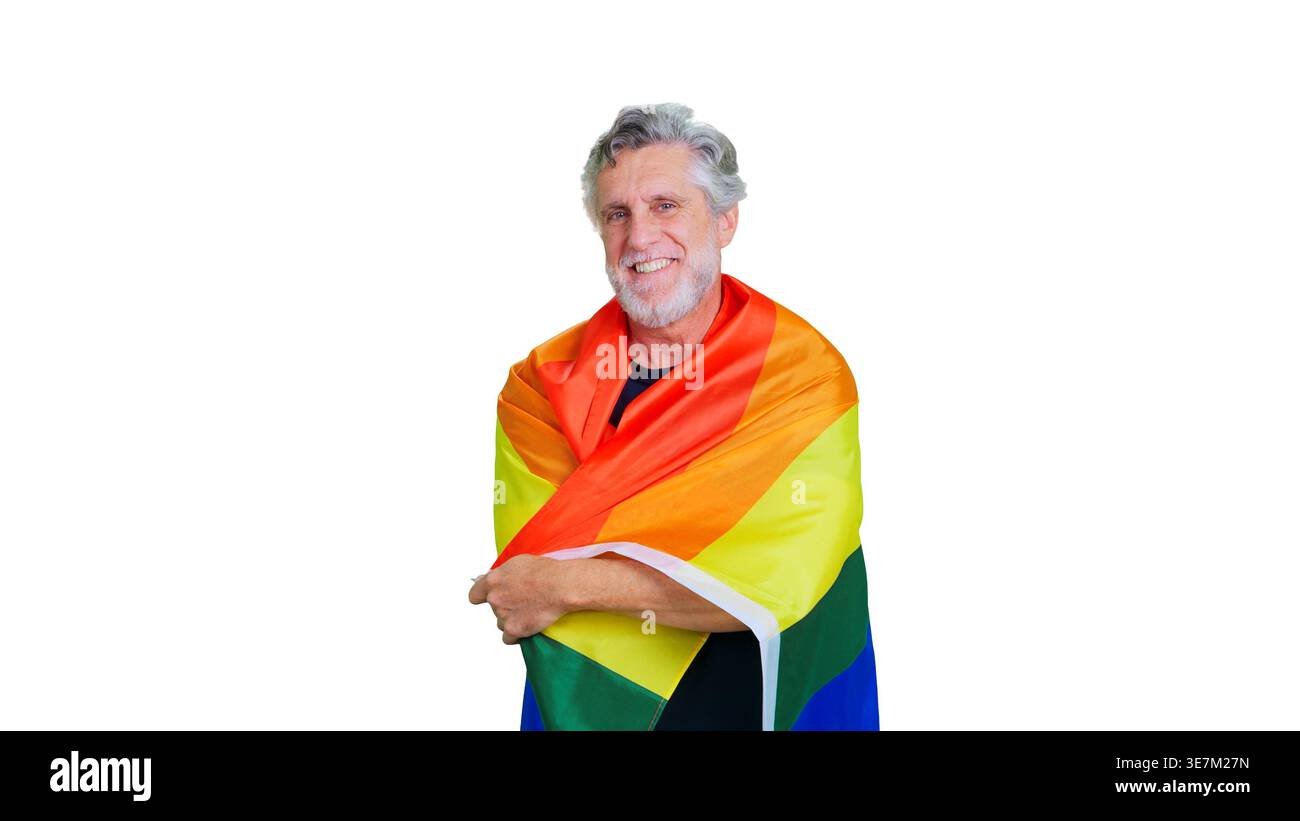 Senior man smiling, embracing rainbow pride flag Stock Photo