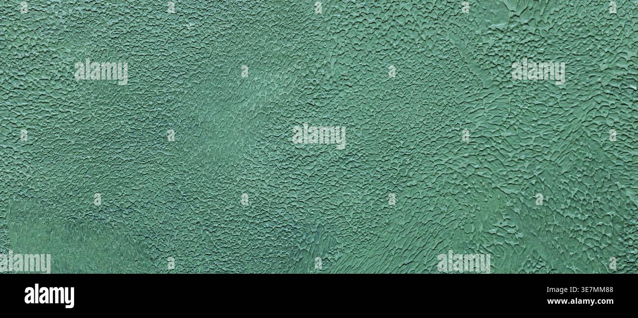 Textured turquoise painted wall surface with cracked weathered paint and rough pattern Stock Photo