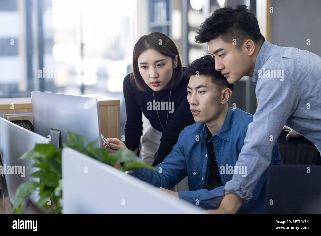 Chinese IT experts working together on computer in office Stock Photo