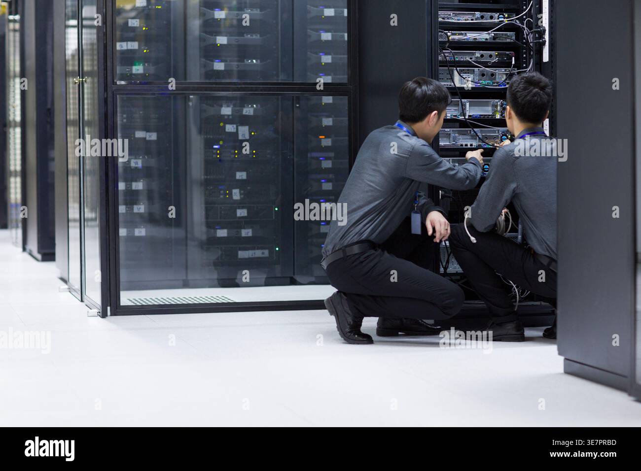 Chinese male technicians doing maintenance in computer room Stock Photo