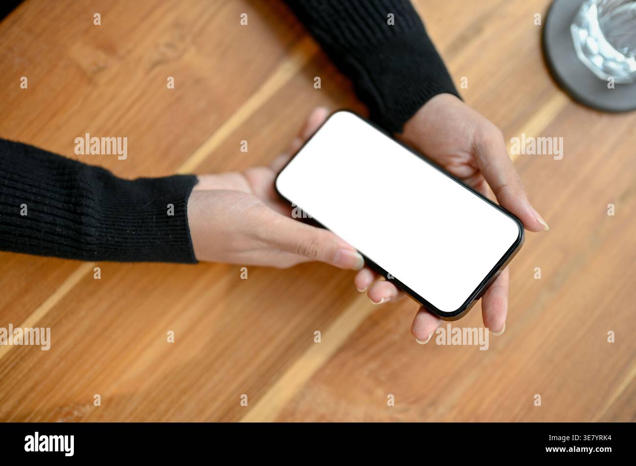 Asian female using smartphone while sitting at table in office Stock Photo