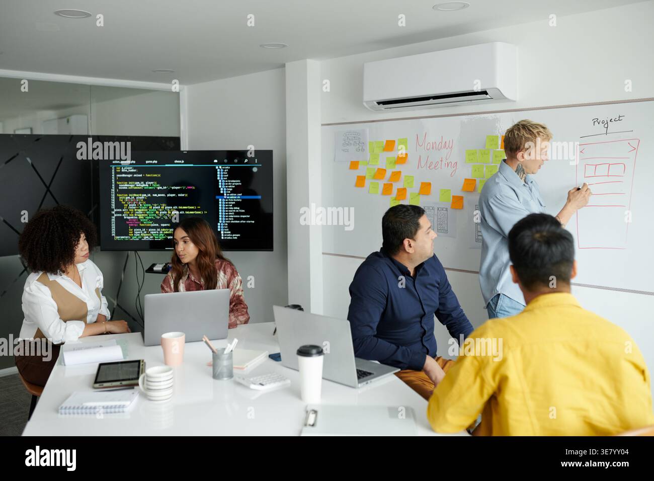Group of developers working as team on new big project discussing programming code in office Stock Photo