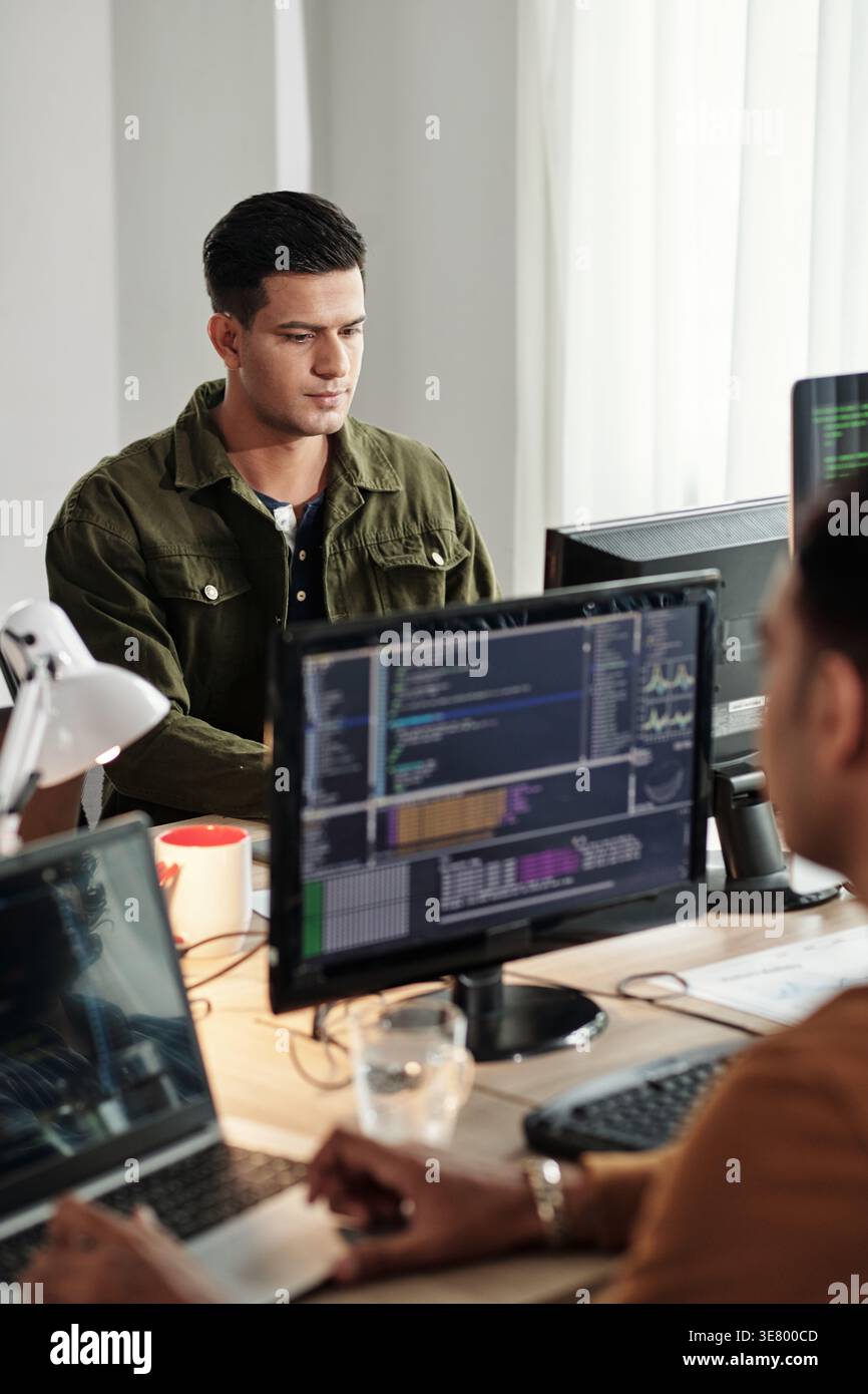 Indian male web developers writing codes for new computer program in IT office Stock Photo