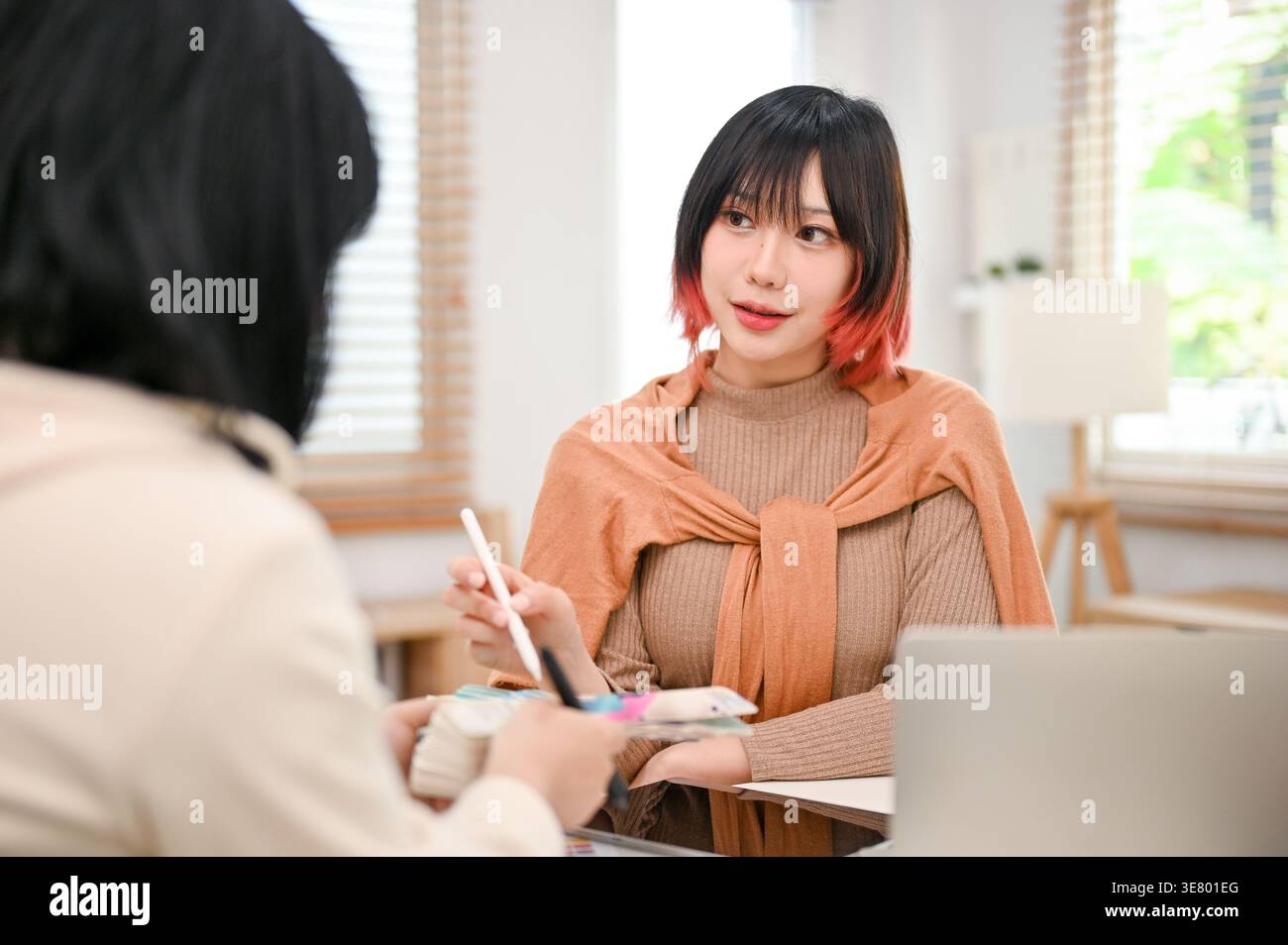 Asian female graphic designers working on their new design project while sitting at table in office Stock Photo
