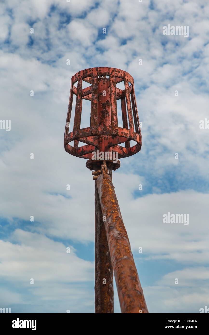 A rusty groyne marker or navigation markerat Sidmouth, Devon, England Stock Photo