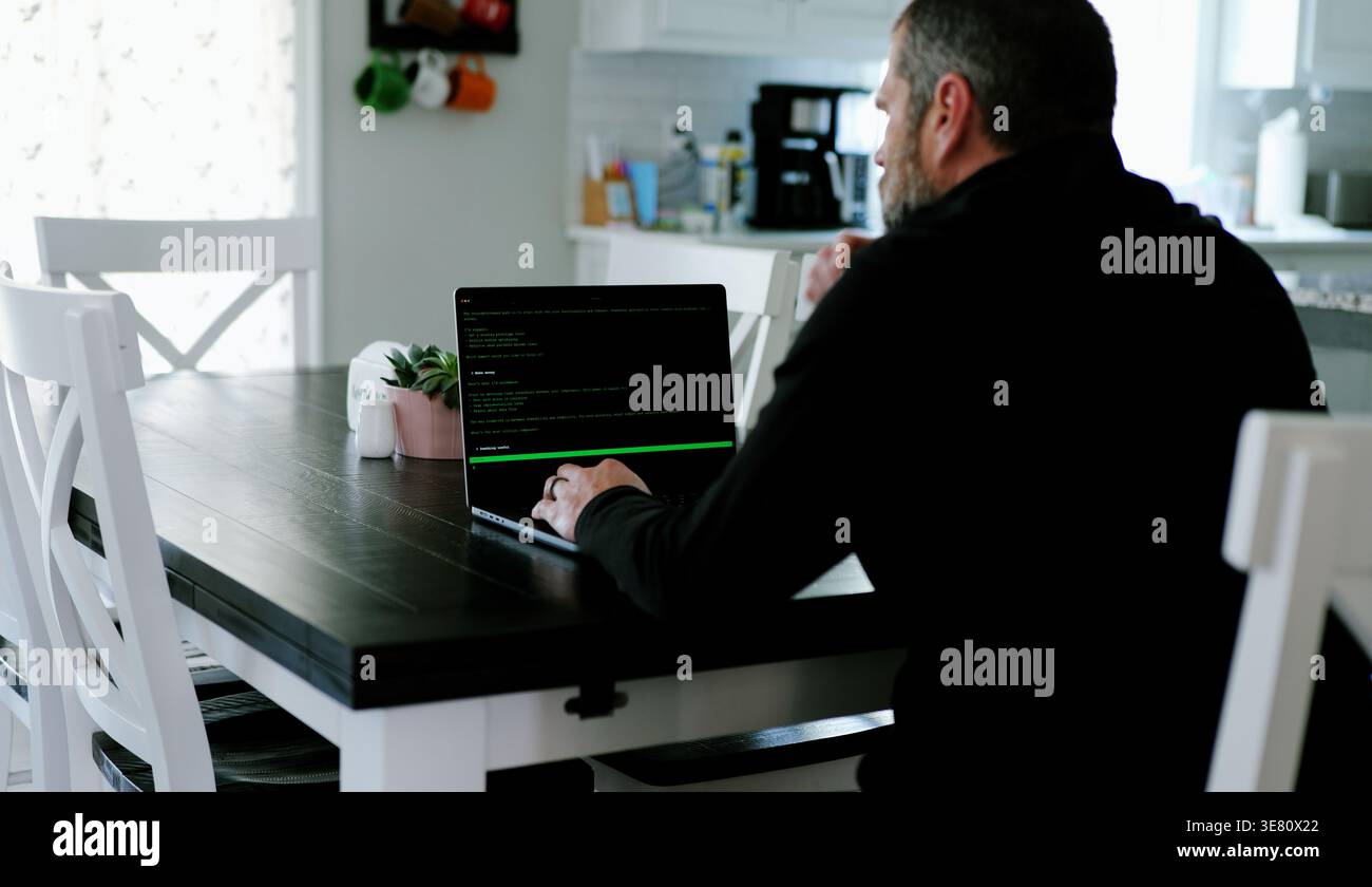 Vibe Coding Software Engineer Developing Billion Dollar Applications at Kitchen Table on Saturday Morning - AI Vibe Coder Concept Stock Photo