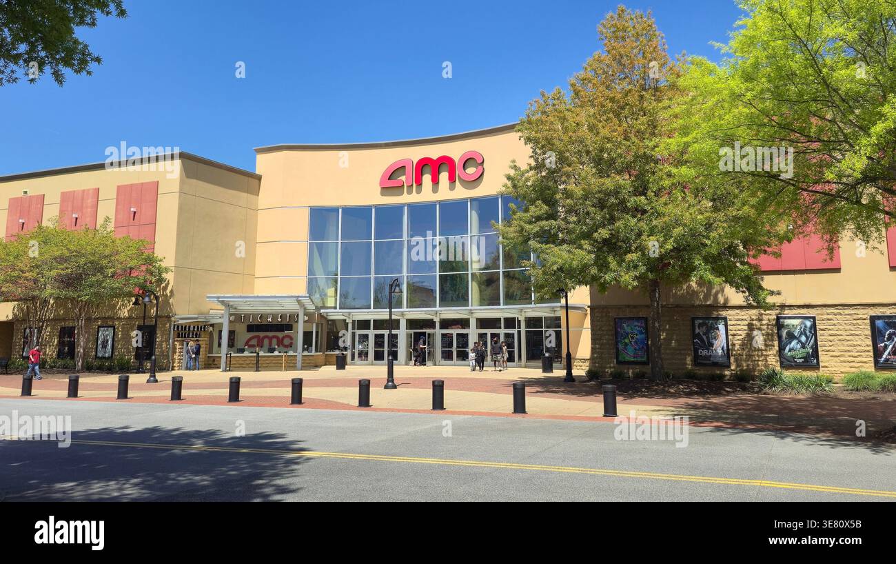 AMC movie theater exterior with branded signage, cinema entrance and movie posters, people near entrance on sunny day, USA - Smartphone Captured Stock Image
