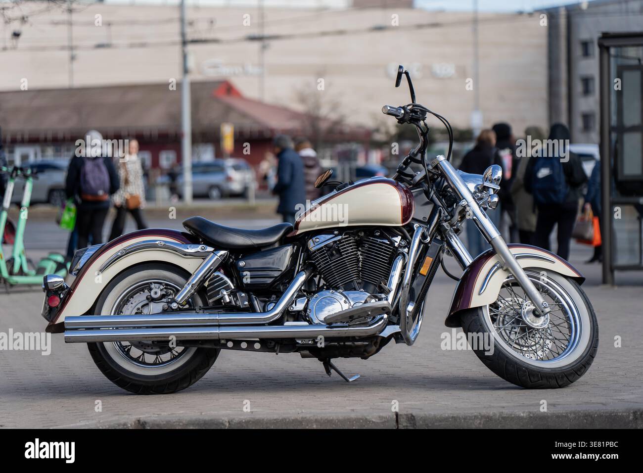 Retro style cruiser motorbike with whitewall tires, chrome details and teardrop tank standing in city surroundings, freedom driven urban transport Stock Photo