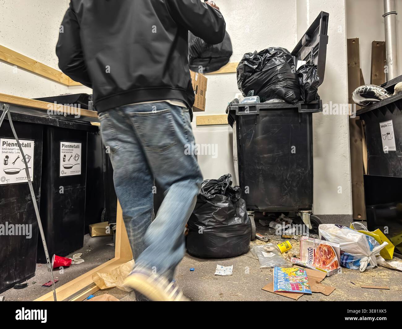 Overflowing waste containers in a Verkkosaari, Helsinki apartment building trash room. - Smartphone Captured Stock Image