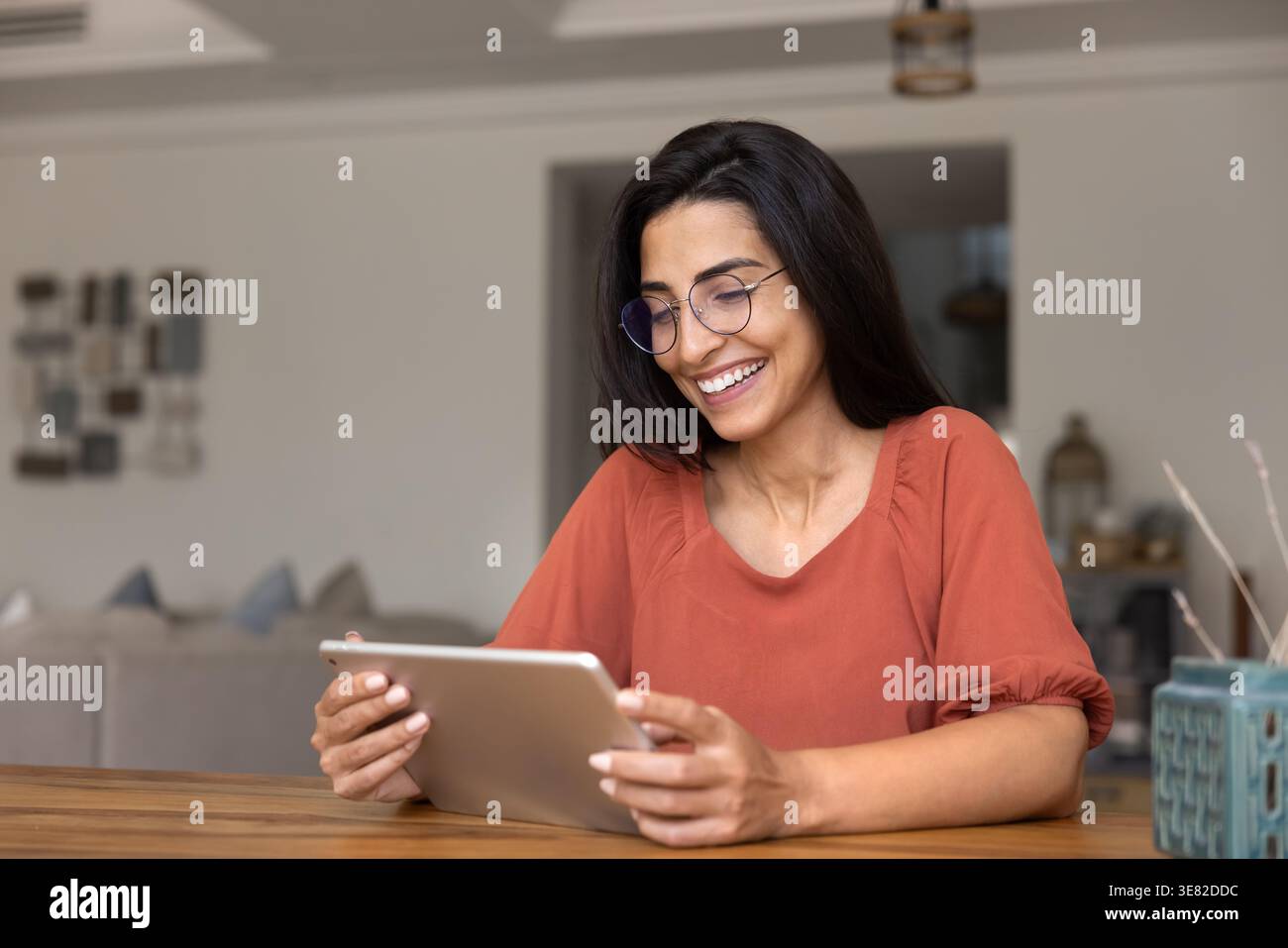 Smiling woman using digital tablet at home Stock Photo