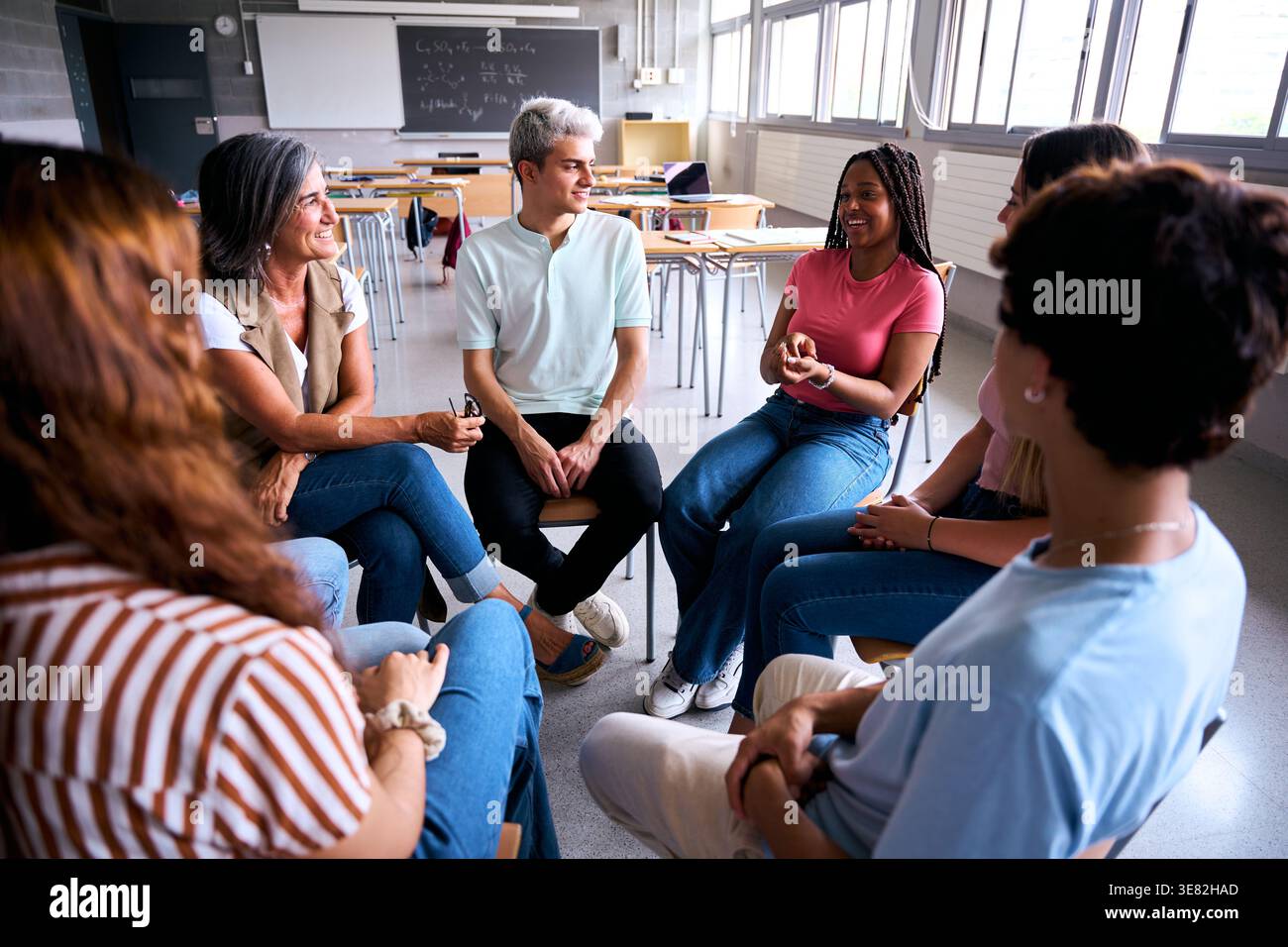 Students and teacher having group discussion in circle Stock Photo