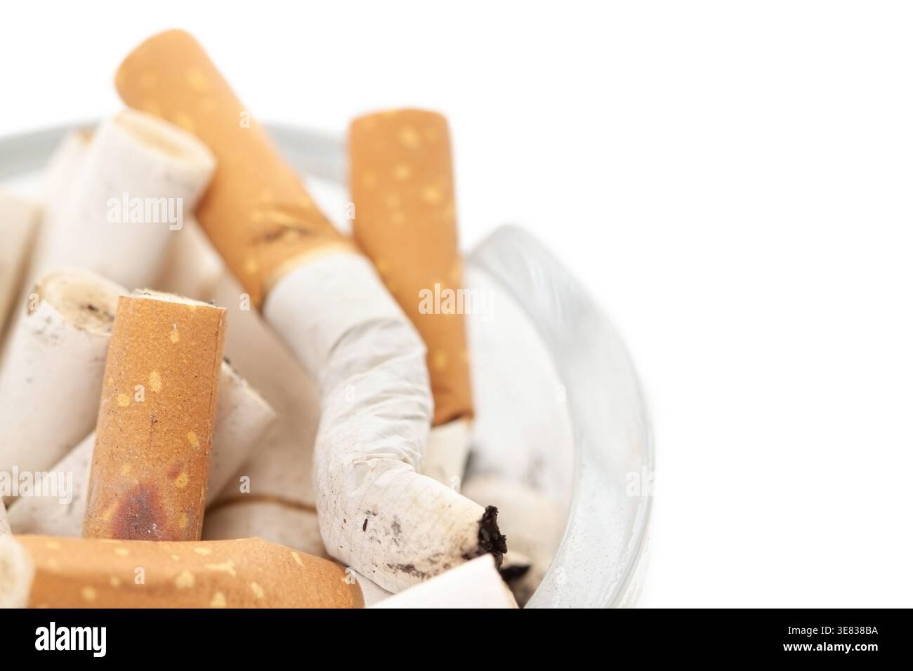 Bunch used cigarettes inside ashtray isolated white background macro corner view Stock Photo