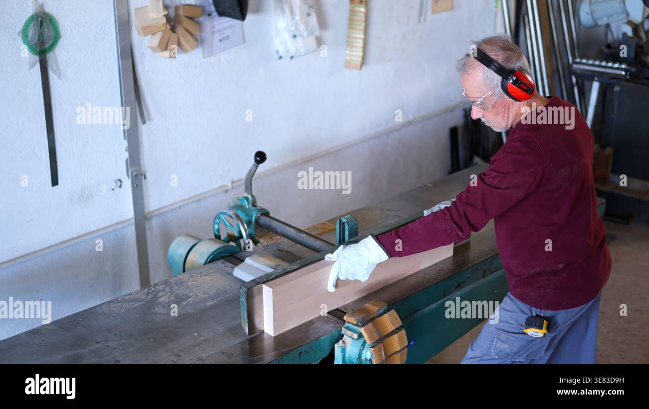 Senior man working wood with jointer machine Stock Photo