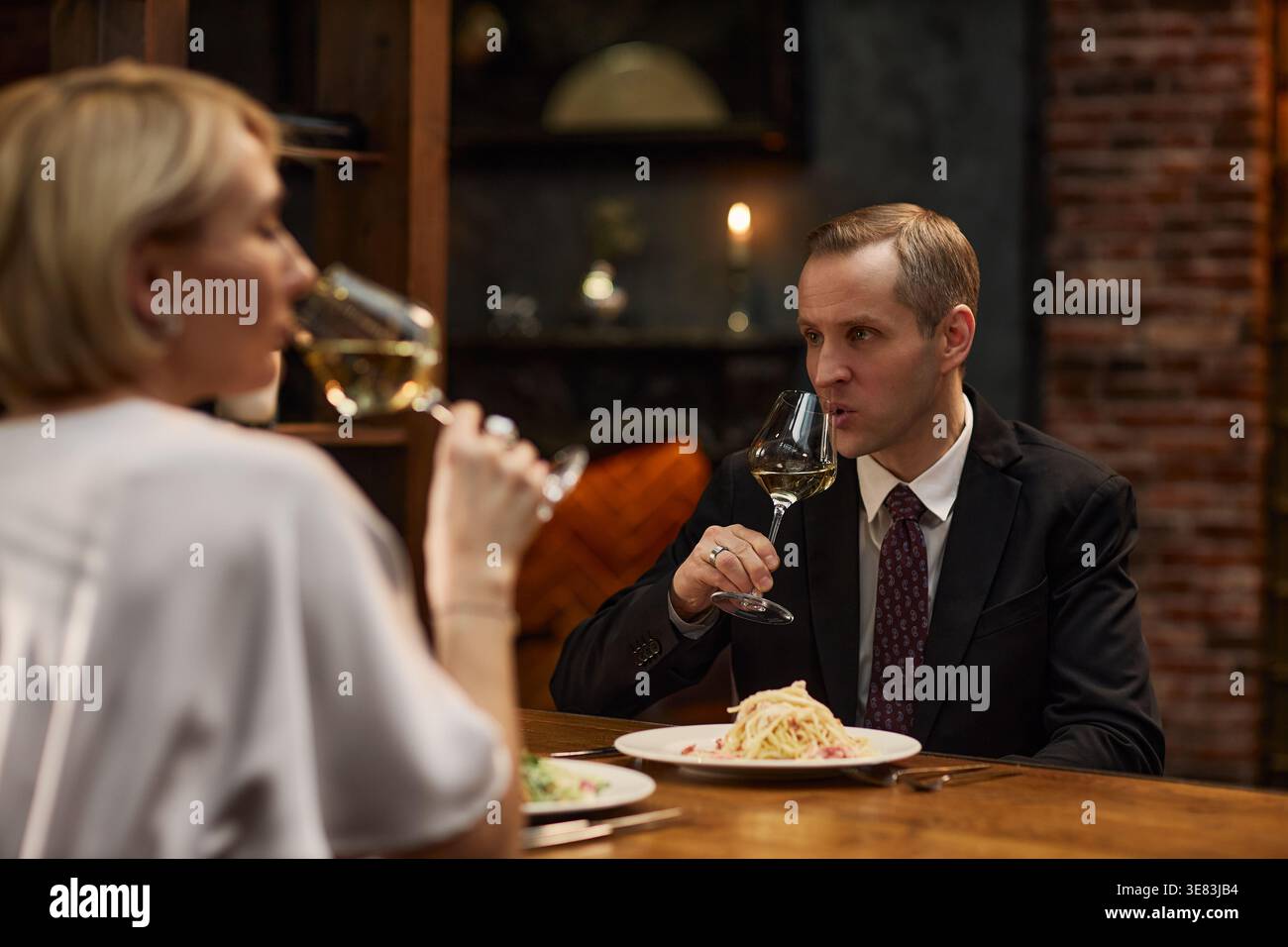 Middle Aged Couple Drinking Wine during Dinner Meeting Stock Photo