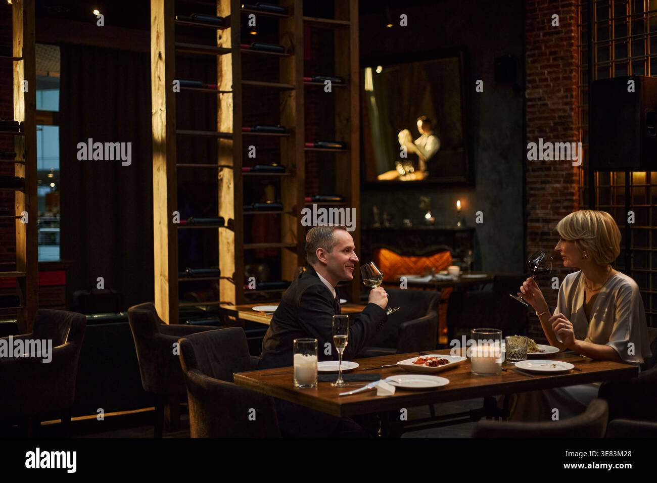 Middle Aged Couple Drinking Wine during Upscale Dinner Date Stock Photo