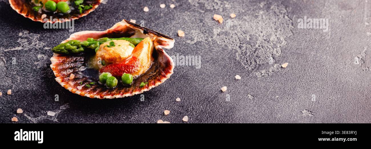 Cooked scallops with vegetables on a dark background Stock Photo