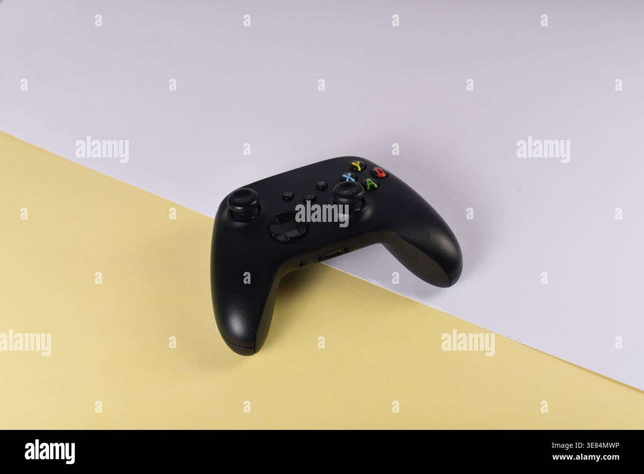 Black videogame controller on desk surface Stock Photo