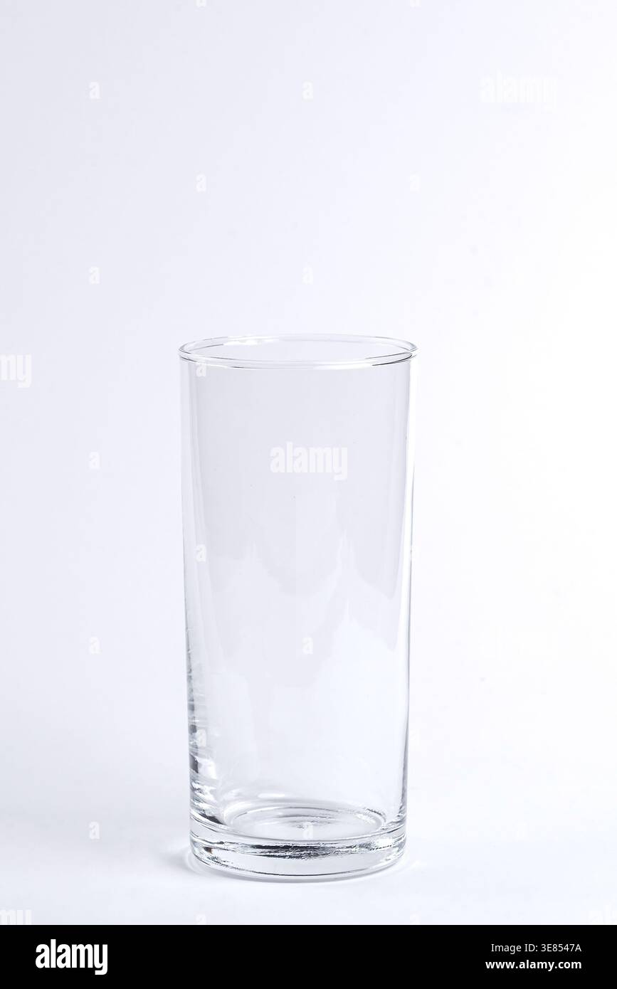 A tall empty clear glass standing on a white background. Stock Photo