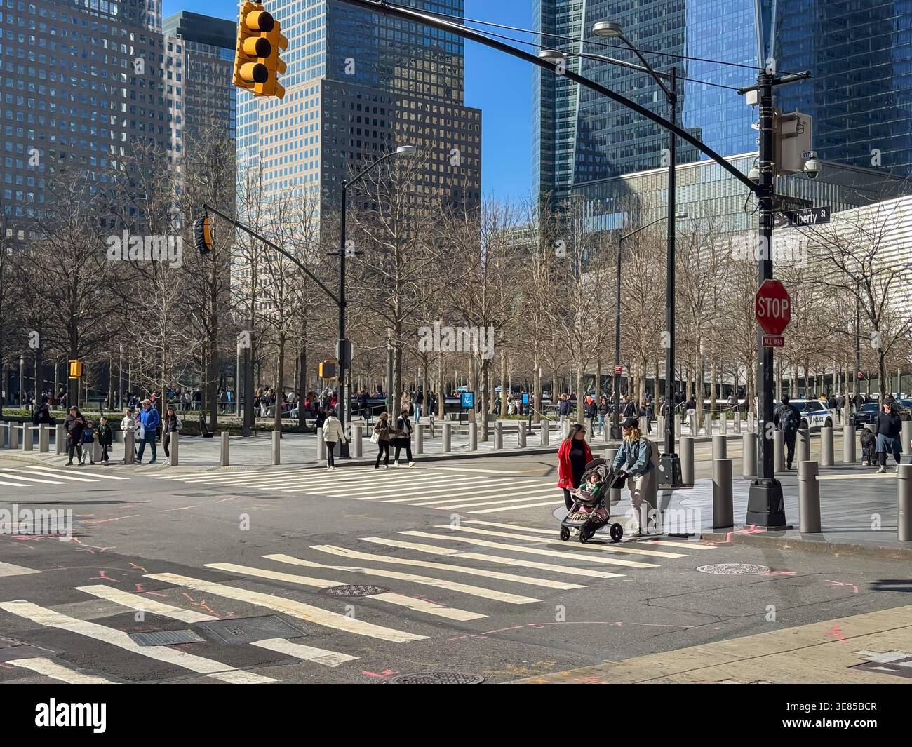 USA New York April 17, 2025. People walk across a crosswalk near modern skyscrapers in Lower Manhattan. The urban intersection captures everyday life Stock Photo
