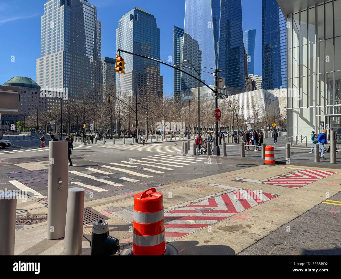 USA New York April 17, 2025. Pedestrians cross a busy intersection near the World Trade Center complex. Modern skyscrapers and open public spaces defi Stock Photo