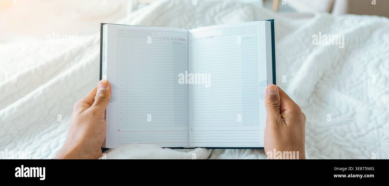 Holding a Blank Notebook in Bed While Getting Ready for the Day Ahead Stock Photo
