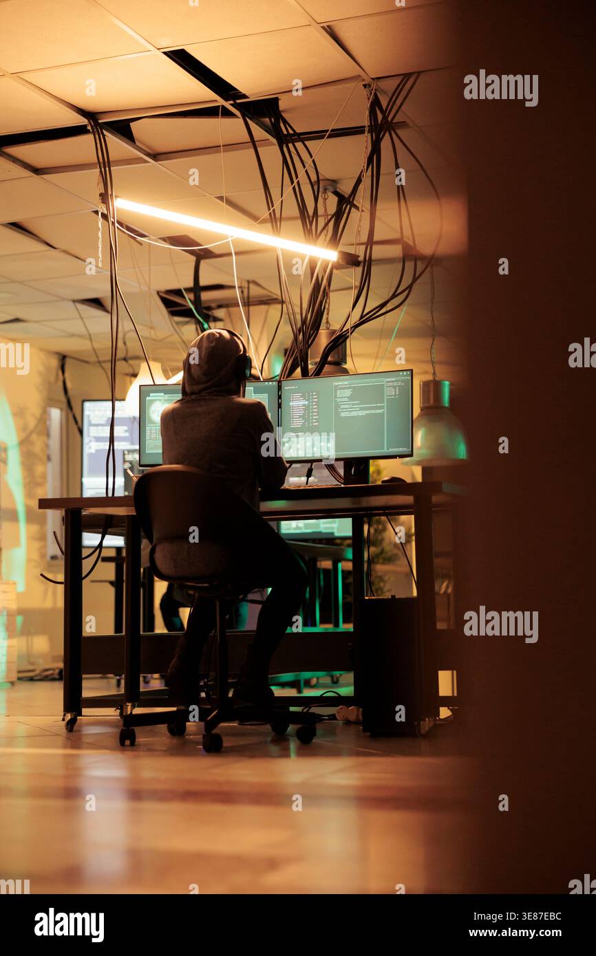 Female thief analyzing online codes to hack government database, attacking sensitive system and causing security breach. Spies hacking network and stealing information late at night. Stock Photo