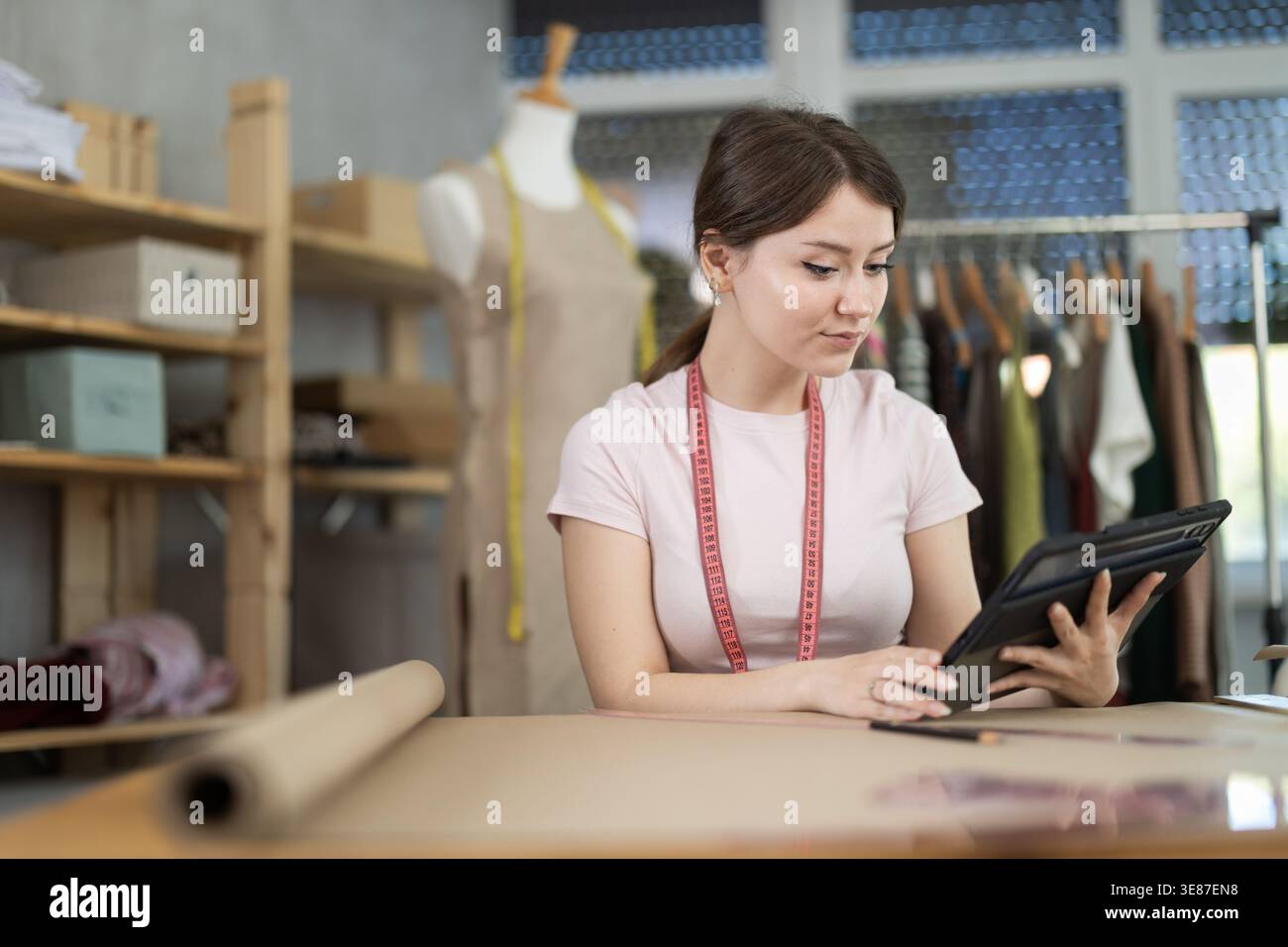 Woman dressmaker makes pattern using tablet Stock Photo