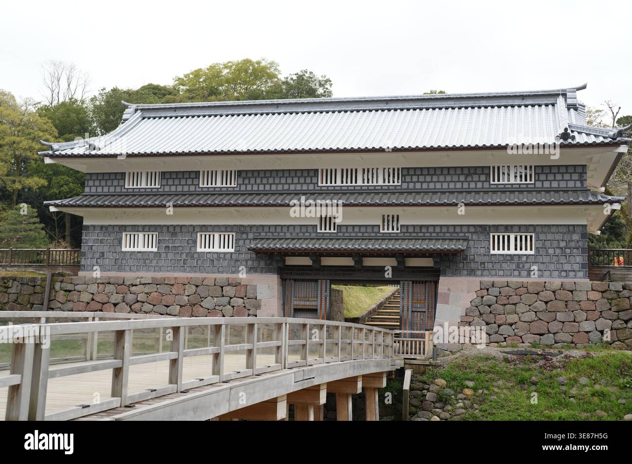 Frame Gate Japan Traditional Japanese gate stands proud beside stone wall. Wooden bridge ...
