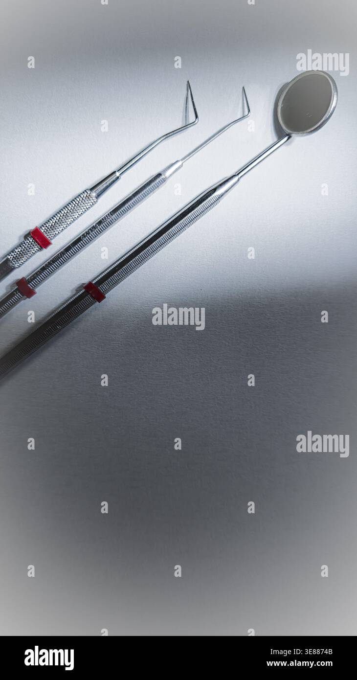 Dental tools on white background, mirror and probes for oral checkup, clean vertical composition Stock Photo