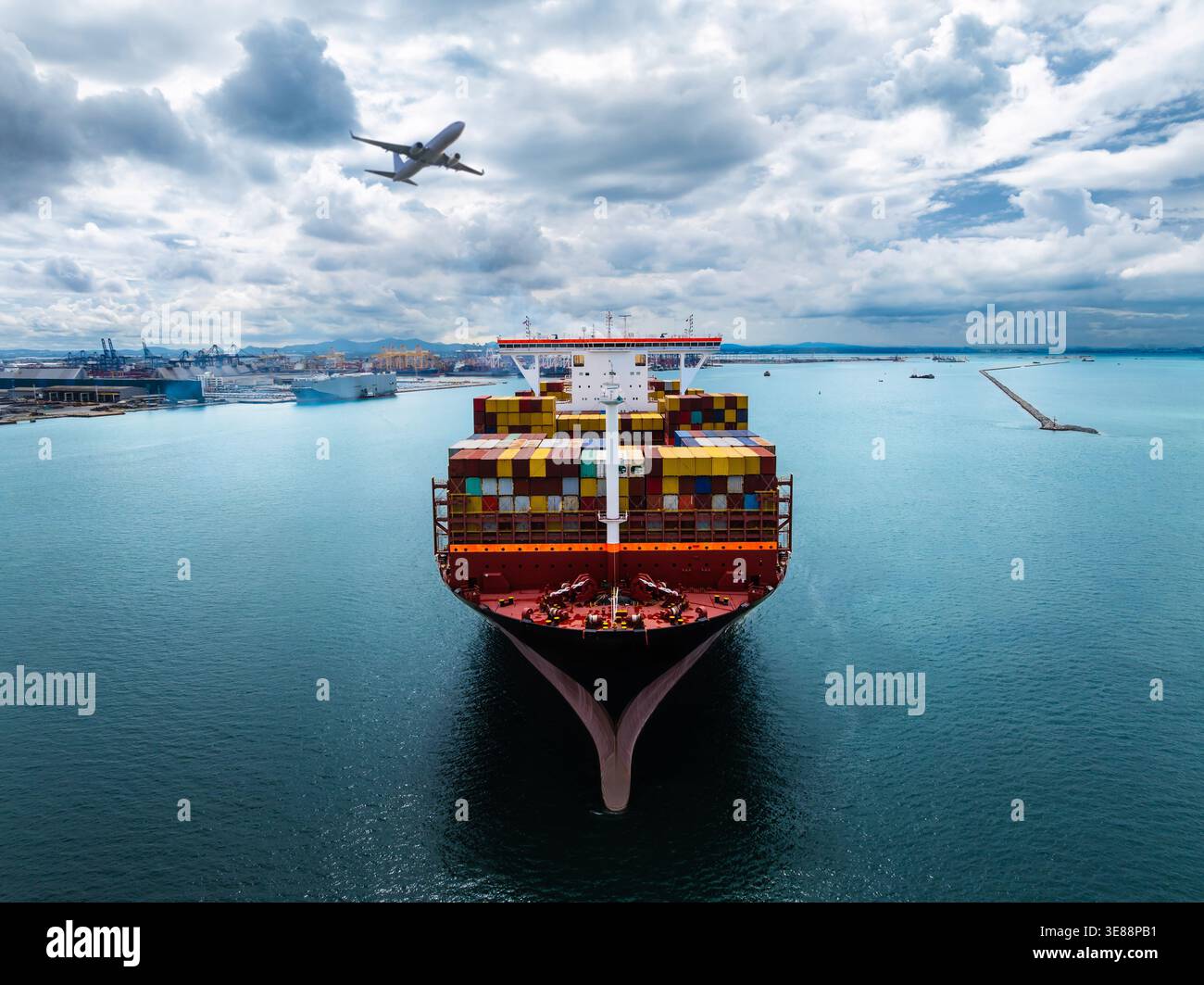 A massive cargo vessel transporting stacked shipping containers arrives ...
