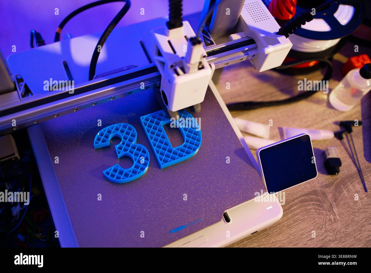 3D Printer Creating Blue Letters Stock Photo
