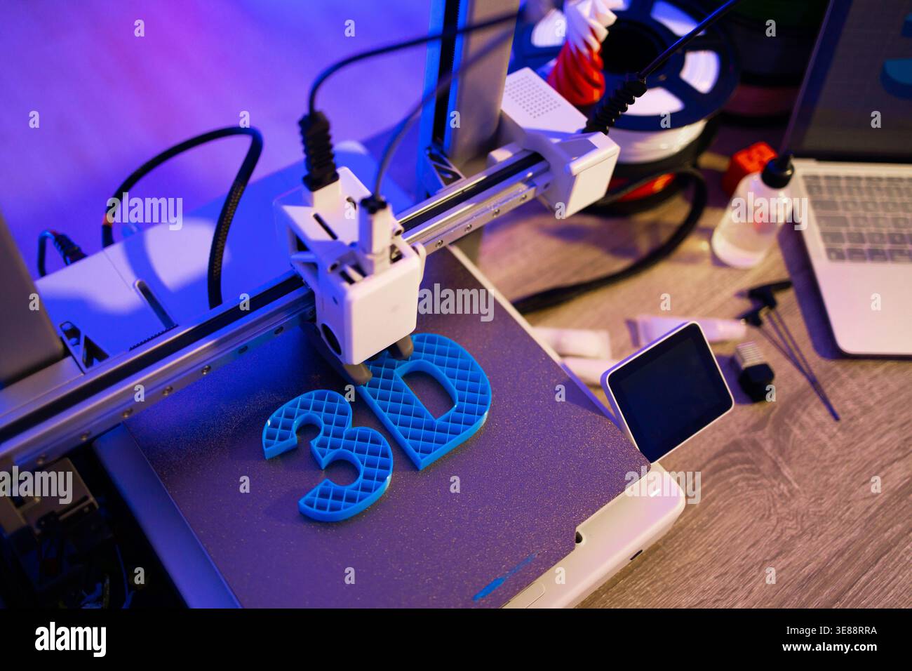 3D Printer Creating Blue Letters Stock Photo