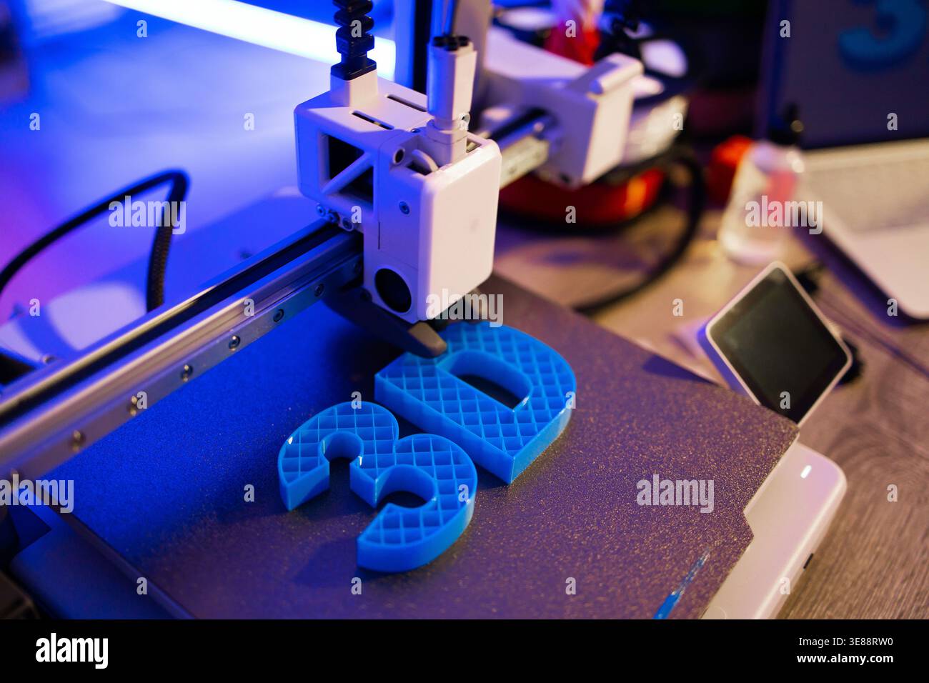 3D Printer Creating Blue Letters Stock Photo