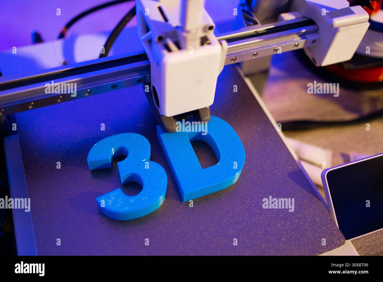 3D Printer Creating Blue Letters Stock Photo