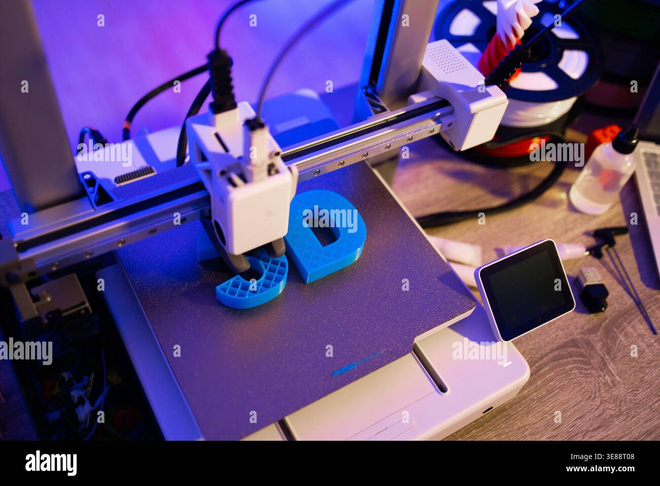 3D Printer Creating Blue Letters Stock Photo