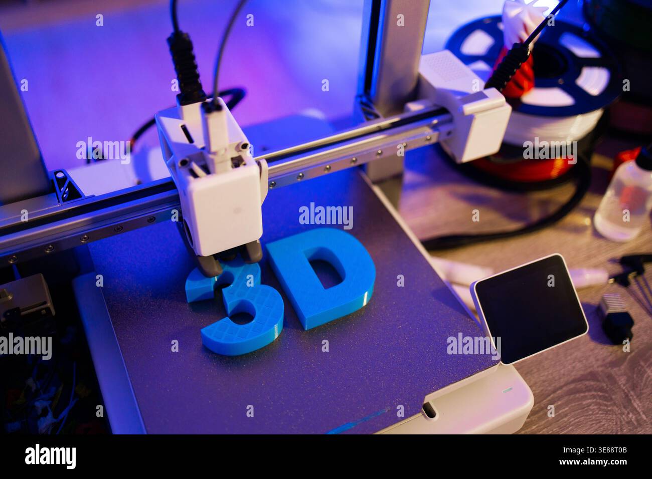 3D Printer Creating Blue Letters Stock Photo