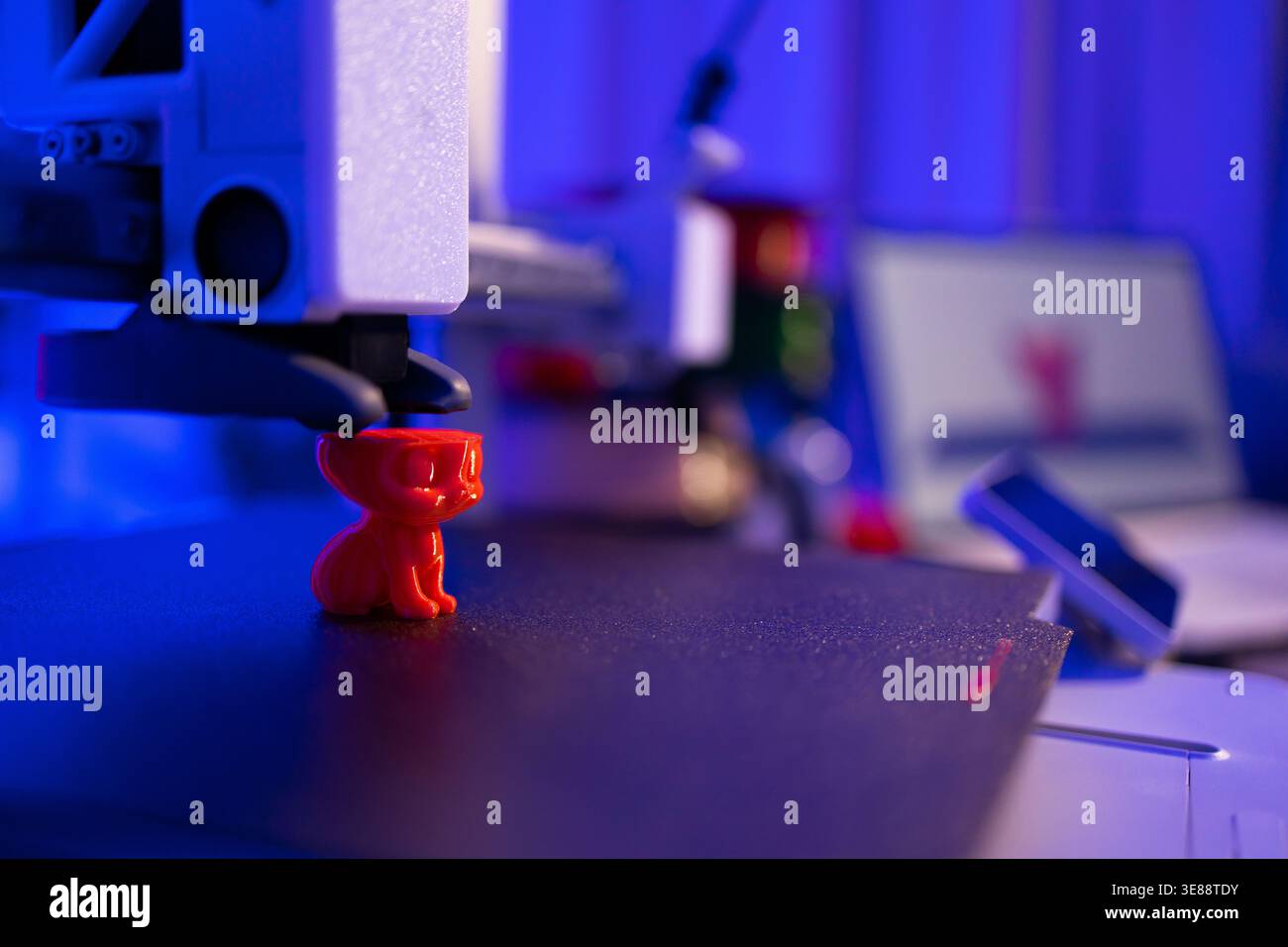 3D Printer Creating Red Cat Figurine Stock Photo