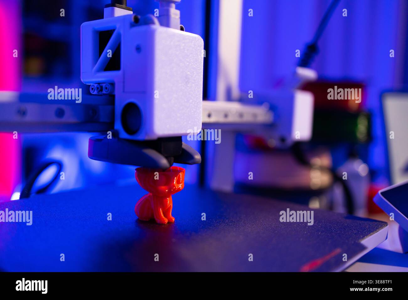 3D Printer Creating Red Cat Figurine Stock Photo
