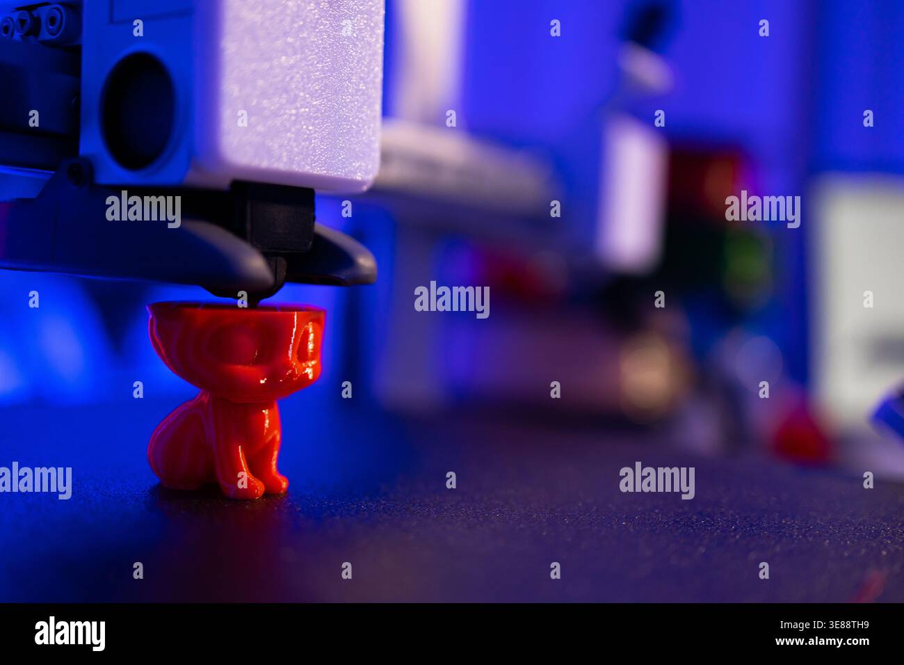 3D Printer Creating Red Cat Figurine Stock Photo