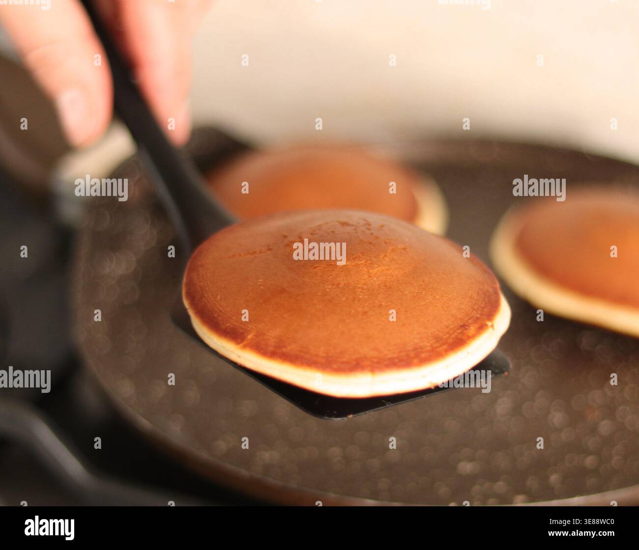 Japanese dorayaki pancakes. Golden fluffy pancakes cooking on a nonstick pan Stock Photo
