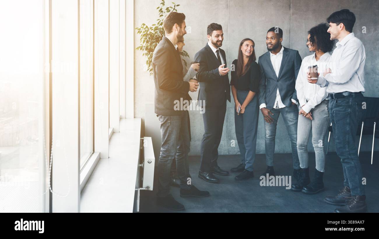 Colleagues talking at coffee break near window Stock Photo