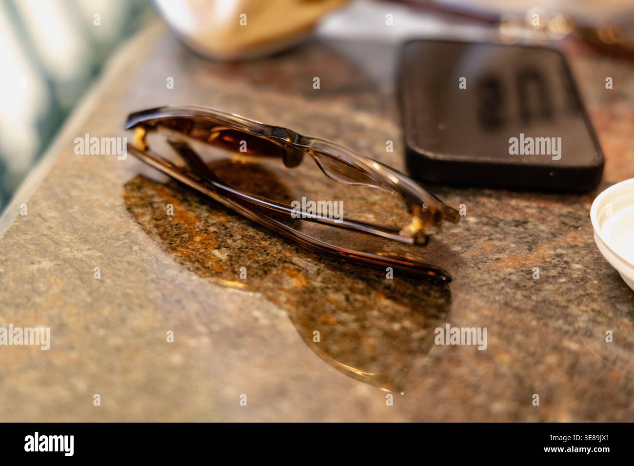 Folded Tortoise Shell Glasses Beside Smartphone Stock Photo