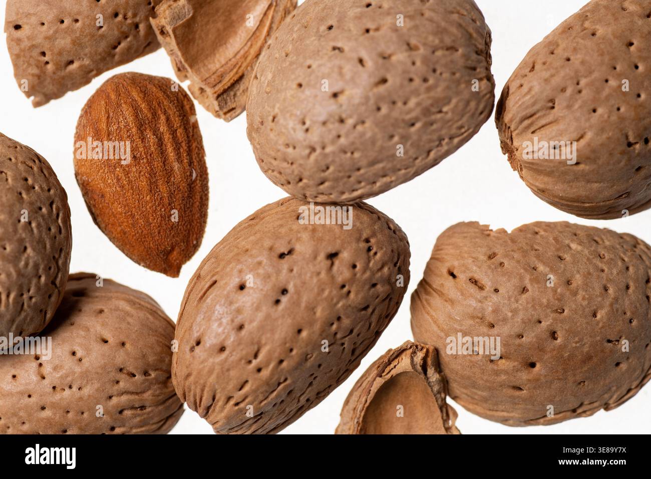 Almonds with shells placed on a surface for food design. Stock Photo