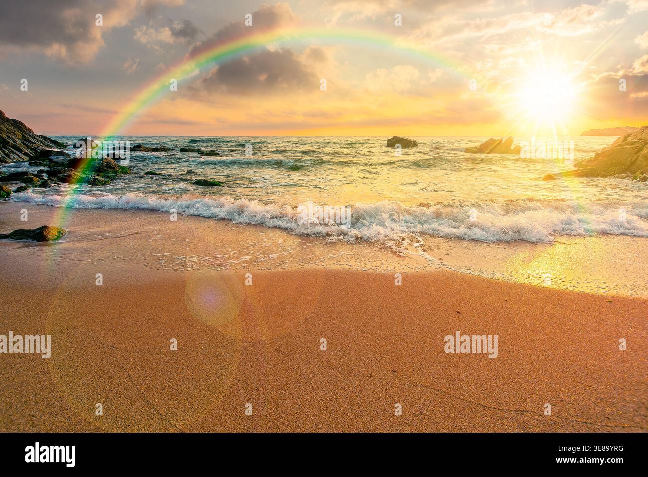sunset over sandy sea beach. scene on hot summer vacation season. beautiful view of waves washing the sand. generic image of seascape and sky with rai Stock Photo