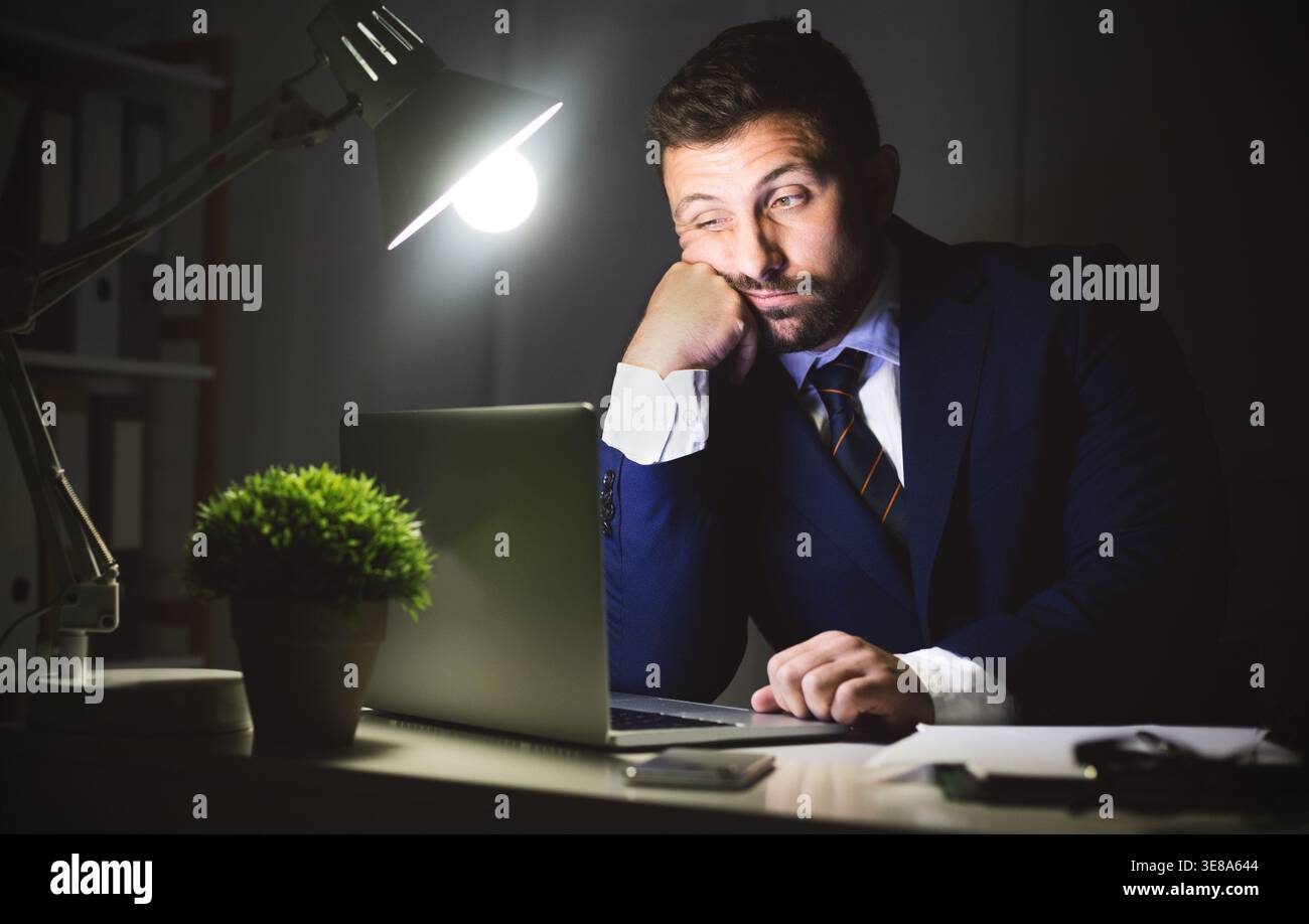 Overwork. Businessman working on laptop in office Stock Photo