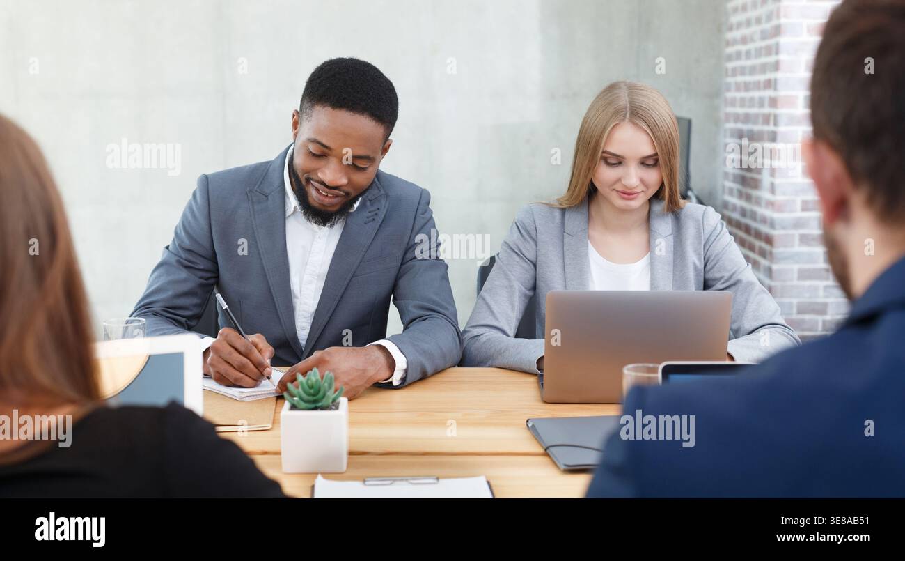 Hr managers interviewing job applicants, making notes Stock Photo