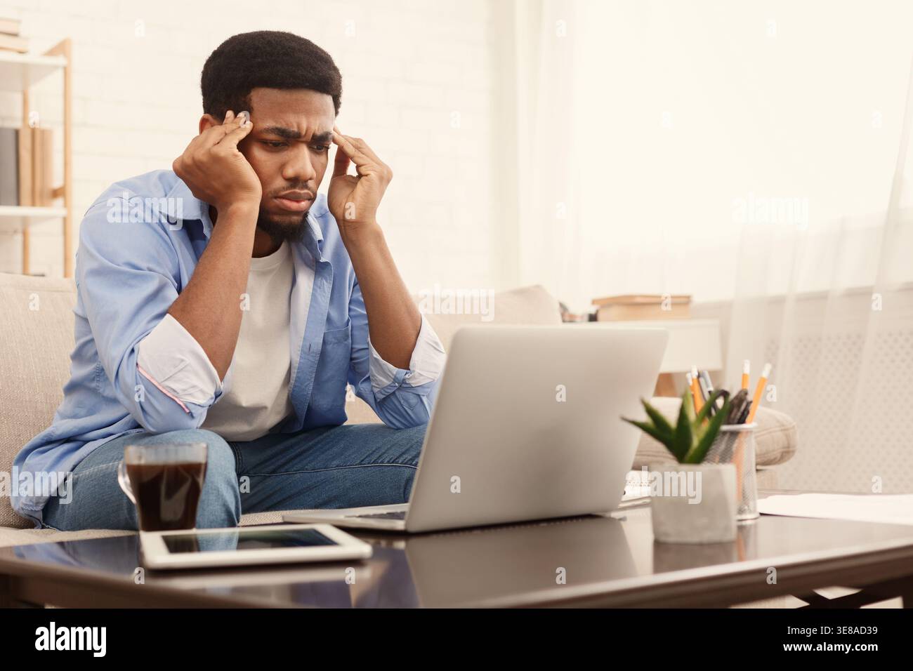 Concentrated black man analizing information on laptop Stock Photo